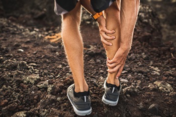 runner holding calf muscle